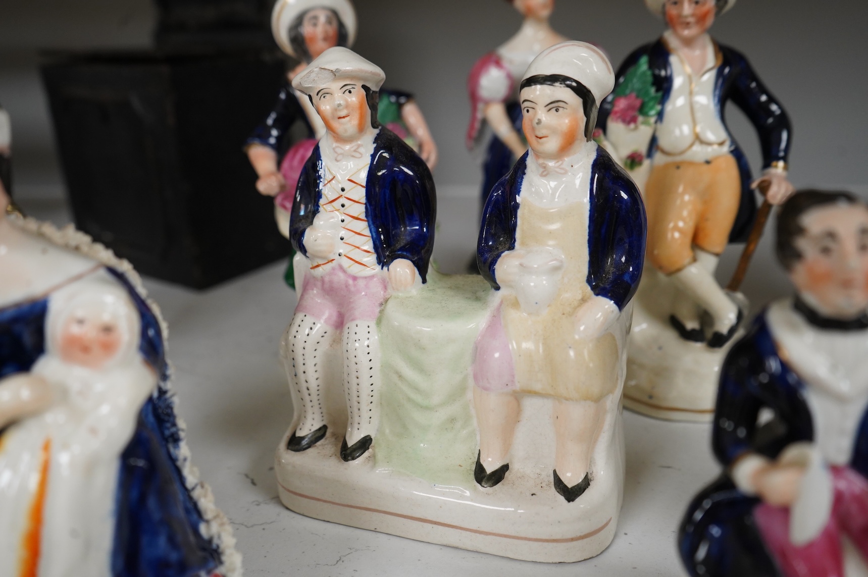 A group of mid-19th century Staffordshire porcelain figures, two models of zebras and a early 19th century Derby biscuit porcelain figure of a seated lady, largest 18cm high